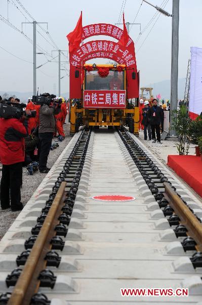 Workers operate machine to lay the last track of the Beijing-Shanghai high-speed railway in Bengbu City, east China's Anhui Province, Nov. 15, 2010. 