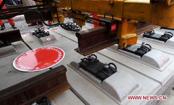 Workers operate machine to lay the last track of the Beijing-Shanghai high-speed railway in Bengbu City, east China's Anhui Province, Nov. 15, 2010. 