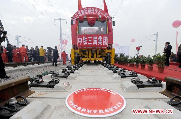 Workers operate machine to lay the last track of the Beijing-Shanghai high-speed railway in Bengbu City, east China's Anhui Province, Nov. 15, 2010. 