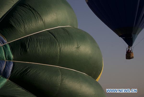 People ride a hot air balloon during a trial session in Tlahuac, southeast of Mexico City, capital of Mexico, on Nov. 13, 2010.