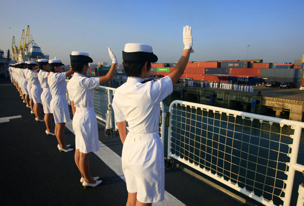 Female crew members of the Chinese Navy hospital ship Peace Ark wave to people seeing them off, Nov 15, 2010.