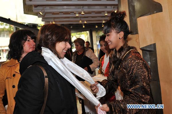 A Chinese Tibetan girl represents a hada to a visitor during the Week of the 2010 China Tibetan Culture in Madrid, Spain, Nov. 15, 2010.