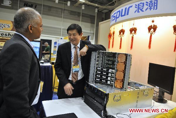Leijun Hu (R), CTO of China's Inspur, introduces eight-processor server Tiansuo TS850 during the supercomputing exhibition, part of the ongoing Supercomputing Conference (SC10), in New Orleans, Louisiana, the United States, Nov. 16, 2010. 
