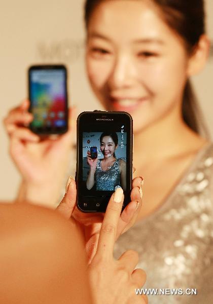A model of Motorola Korea Inc. poses for photos with the company's new smart phone 'Motorola DEFY' during a news conference at Shilla Hotel in Seoul, capital of South Korea on Nov. 16, 2010.