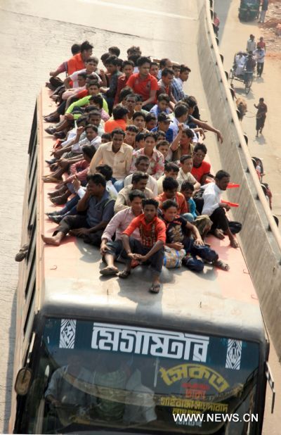 People stay on the rooftop of a homebound bus in Dhaka, capital of Bangladesh on Nov. 16, 2010. 
