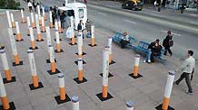 People walk past a giant cigarette installation placed at the Fabiani Plaza, in Montevideo, Uruguay, on Nov. 17, 2010.