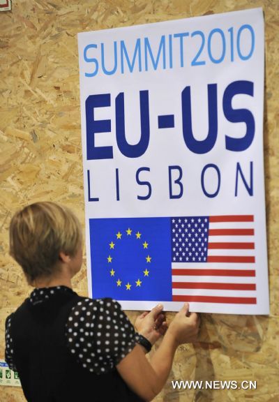 A Staff member puts up poster of EU-US summit in Lisbon, capital of Portugal, on Nov. 18, 2010. 