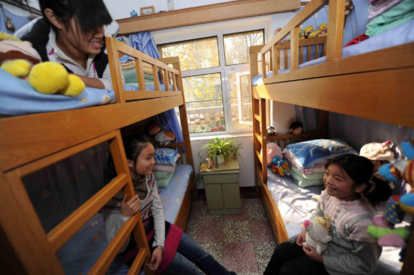 Liu Chongyun (first from right) chats with two girls living in the living room of the SOS Children's Village in Tianjin on Nov 20, 2010. 