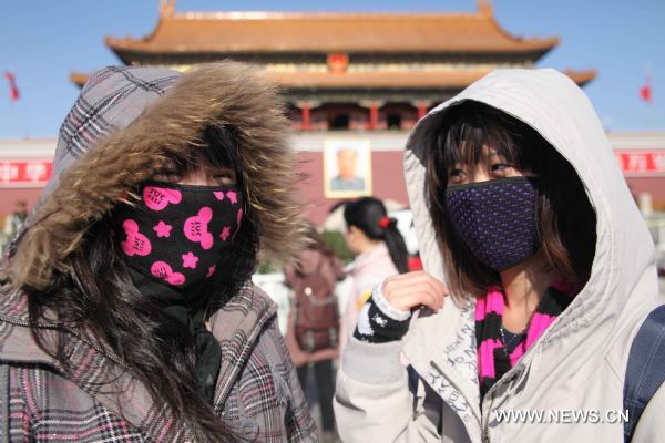 Tourists with face masks walk on the Tian'anmen Square in a clear windy day in Beijing, capital of China, Nov. 21, 2010.