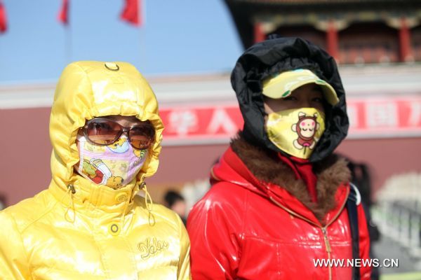 Tourists with face masks walk on the Tian'anmen Square in a clear windy day in Beijing, capital of China, Nov. 21, 2010.
