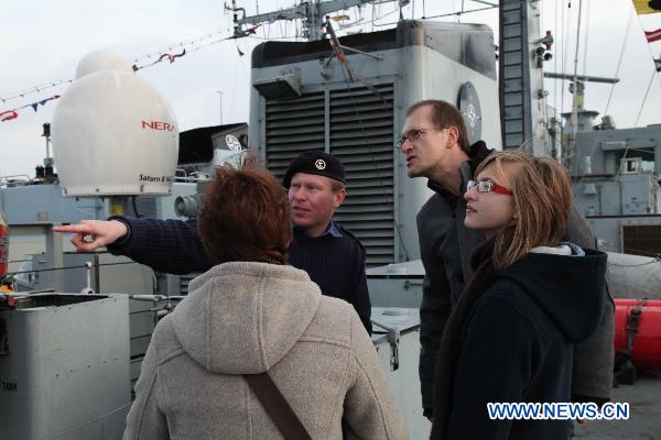 A navy officer introduces the British mine countermeasures vessel called 'Penzance' to visitors at the navy base in Zeebrugge, Belgium, Nov. 21, 2010. 