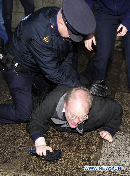 A protester is arrested after trying to stop the car carrying Irish Tourism, Culture and Sport Minister Mary Hanafin as she arrives for a cabinet meeting at the Government Buildings, in Dublin, Ireland, Nov. 21, 2010. 