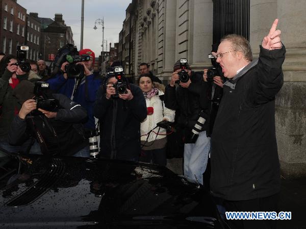 A protester stops the car carrying Irish Tourism, Culture and Sport Minister Mary Hanafin as she arrives for a cabinet meeting at the Government Buildings, in Dublin, Ireland, Nov. 21, 2010.