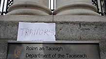 A placard reading 'Traitors' is placed at the gate of the Government Buildings, in Dublin, Ireland, Nov. 21, 2010.