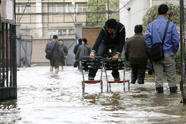 People wade through a waterlogged road in Zhengzhou, capital of central China's Henan Province, Nov. 22, 2010. 
