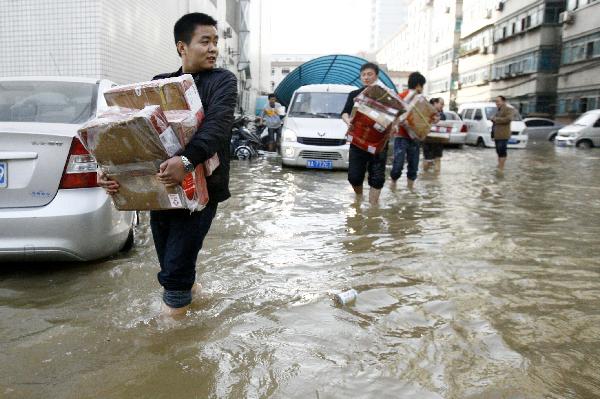 People transfer flooded goods in Zhengzhou, capital of central China's Henan Province, Nov. 22, 2010. 