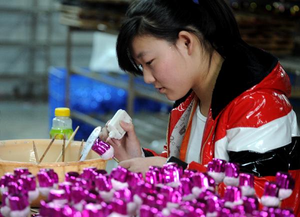 A staff member makes Christmas ornaments in Yiwu City of east China's Zhejiang Province, on Nov. 22, 2010.