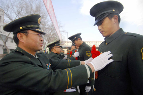 Red flowers are attached to soon-to-be-retired soldiers at a farewell ceremony held at Ningxia Paramilitary Police Corps in Yinchuan, Ningxia Hui autonomous region, Nov 23, 2010.[Xinhua] 