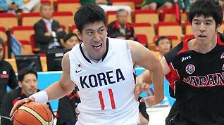 Yang Heejong(L) of South Korea dribbles during the men's basketball semifinal match between South Korea and Japan at the 16th Asian Games in Guangzhou, south China's Guangdong Province, Nov. 25, 2010.