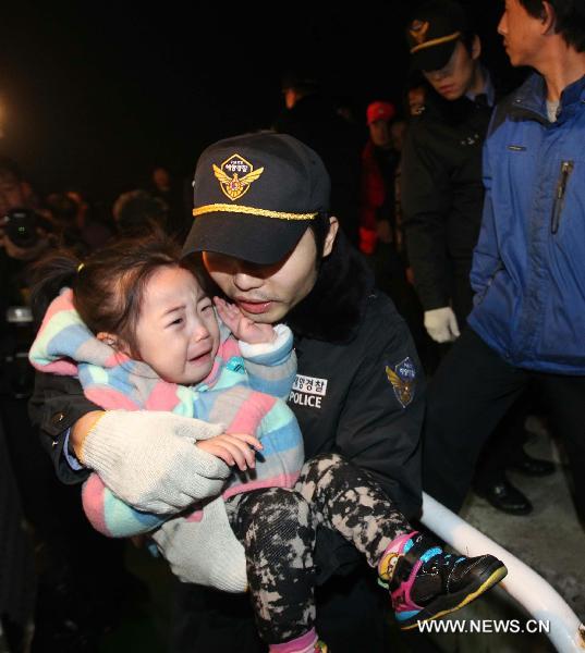 A police officer carries a terrified child on the Yeonpyeong Island hit by artillery shells the Democratic People&apos;s Republic of Korea (DPRK) fired a day ago, Nov. 24, 2010.