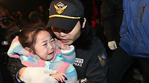 A police officer carries a terrified child on the Yeonpyeong Island hit by artillery shells the Democratic People's Republic of Korea (DPRK) fired a day ago, Nov. 24, 2010.