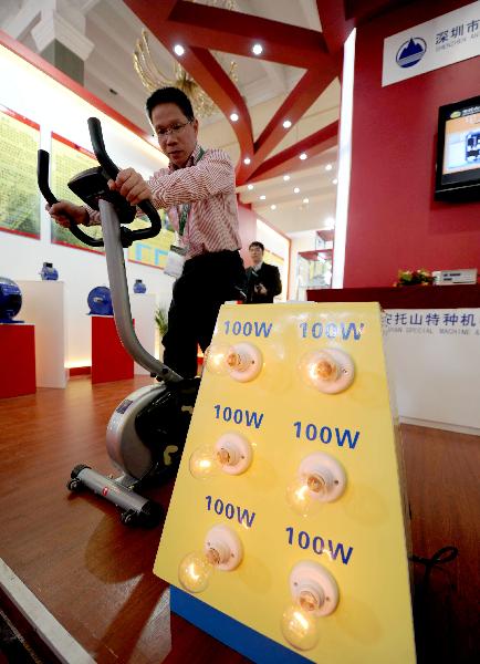 A staff member displays a fitness equipment at China International Green Industry Expo 2010 (CIGIE) in Beijing, Capital of China, on Nov. 24, 2010. 