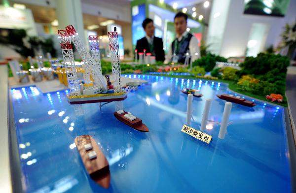 Visitors look at a model of clean energy generation system at China International Green Industry Expo 2010 (CIGIE) in Beijing, Capital of China, on Nov. 24, 2010. 