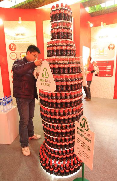 A visitor looks at a recycled plastic bottle at China International Green Industry Expo 2010 (CIGIE) in Beijing, Capital of China, on Nov. 24, 2010. 