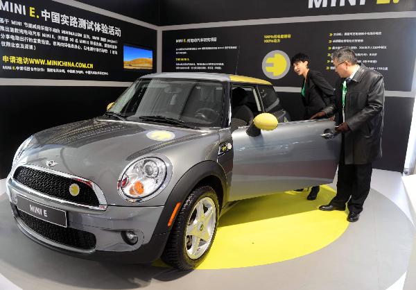 Visitors look at an electromobile at China International Green Industry Expo 2010 (CIGIE) in Beijing, Capital of China, on Nov. 24, 2010. 