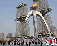 Participants in the closing ceremony for the Asian Games in Guangzhou rehearse under the torch at Haixinsha Island in Guangzhou, Guangdong Province, on Nov. 23, 2010. [chinanews.com]