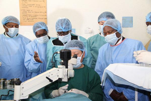 Zimbabwean President Robert Mugabe (3rd L, back) looks at a Chinese doctor doing an operation at Chitungwiza Central Hospital on the suburbs of Zimbabwean capital Harare, Nov. 25, 2010. 