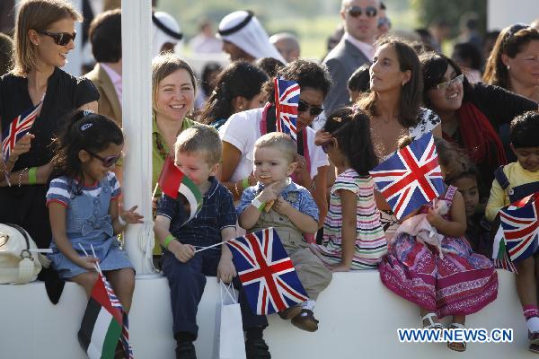 People wait for the arrival of Britain&apos;s Queen Elizabeth II to a ceremony to unveil the design of the Zayed National Museum in Abu Dhabi on Nov. 25, 2010. 