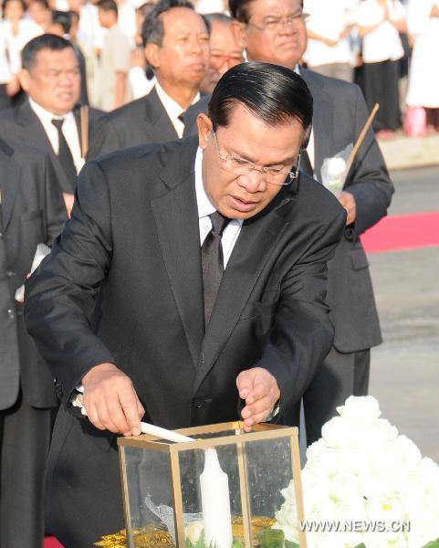 Cambodian Prime Minister Hun Sen lights a candle during the mourning ceremony for stampede victims on the national day of mourning in Phnom Penh Nov. 25, 2010. 