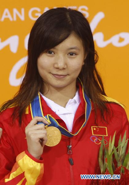 China's He Zi stands on the podium of the women's 3m springboard final of Diving event at the 16th Asian Games in Guangzhou, south China's Guangdong Province, Nov. 26, 2010.