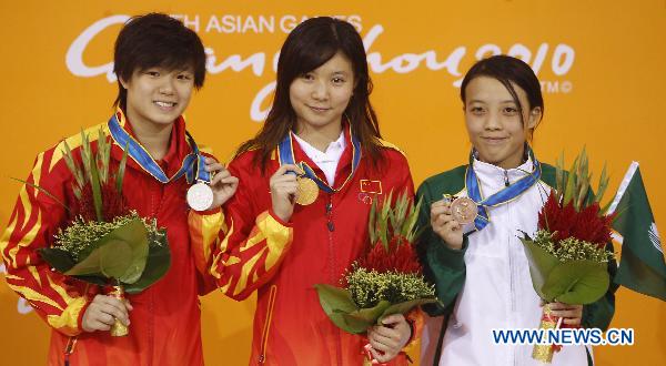 China's He Zi (C), Shi Tingmao (L) and Choi Sut Ian of Macao of China pose on the podium of the women's 3m springboard final of Diving event at the 16th Asian Games in Guangzhou, south China's Guangdong Province, Nov. 26, 2010.