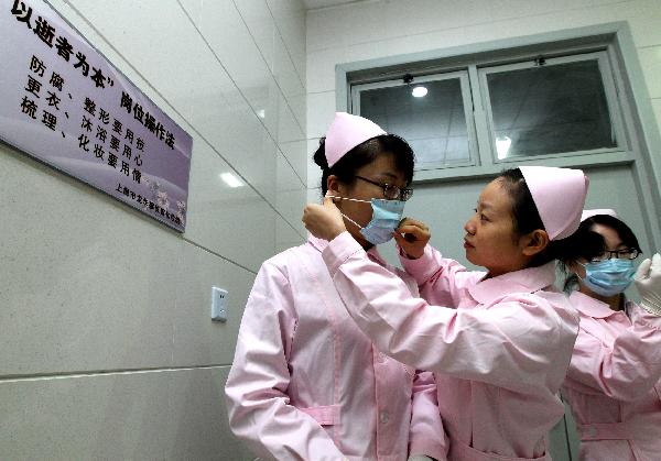 Embalmers get dressed before work in Shanghai, east China, on Nov. 28, 2010.
