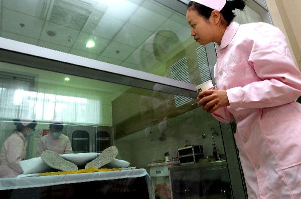 Embalmer Liu Binling (front) watches her colleagues work in Shanghai, east China, on Nov. 28, 2010. 