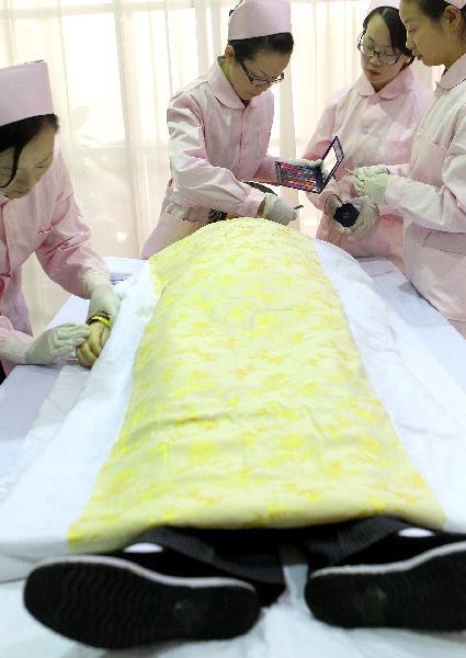 Embalmers help a deceased with makeup in Shanghai, east China, on Nov. 28, 2010. 