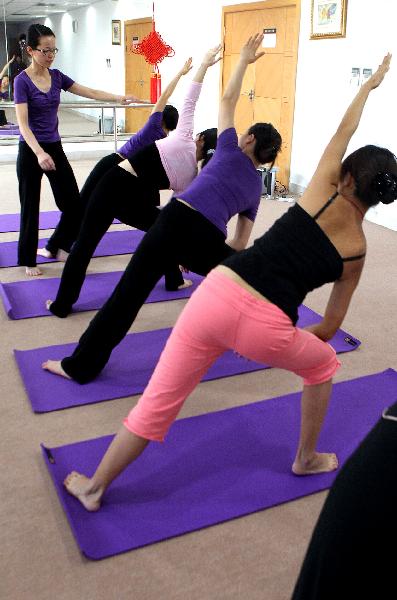 Embalmers practise yoga during their leisure time in Shanghai, east China, on Nov. 27, 2010.