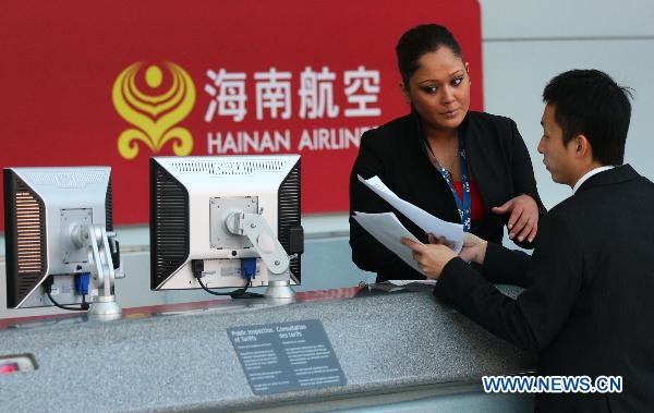 Staff members of Hainan Airlines prepare to provide services for boarding passengers at the counters of Hainan Airlines at Pearson International Airport in Toronto, Canada, Nov. 27, 2010.