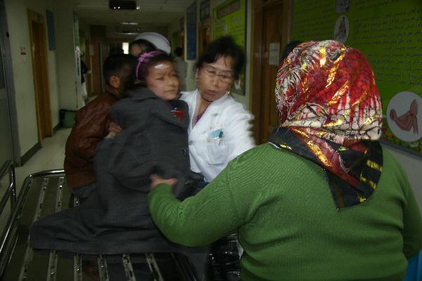 An injured pupil is sent to a hospital in Aksu City, northwest China's Xinjiang Uygur Autonomous Region, Nov. 29, 2010. 