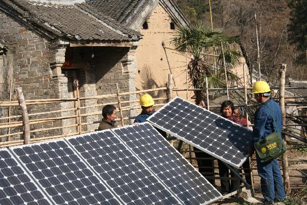 State Grid staffs work with photovotaic battery panels in Neixiang County, central China's Henan Province, Nov 29, 2010. 
