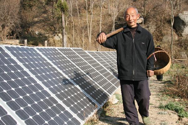 A farmer walks past photovotaic battery panels in Neixiang County, central China's Henan Province, Nov 29, 2010.