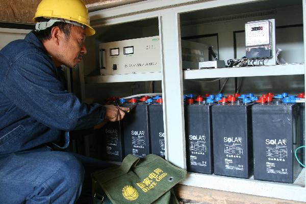State Grid staff works with solar batteries in Neixiang County, central China's Henan Province, Nov 29, 2010.