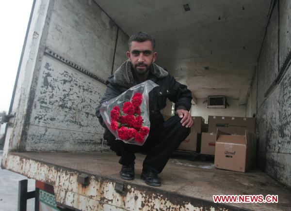 A Palestinian worker displays flowers for export at Kerem Shalom commercial crossing in Rafah, southern Gaza Strip, Nov. 28, 2010.