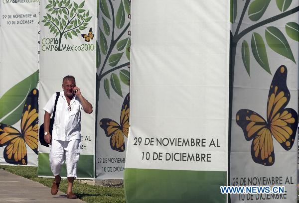 A man walks past the banners of the United Nations Climate Change Conference (COP-16) in Cancun, Mexico, Nov. 29, 2010. 