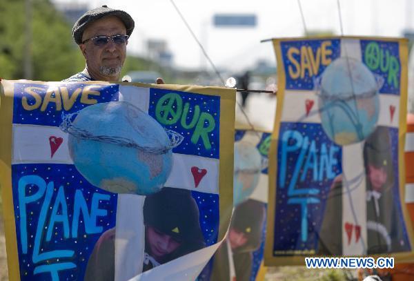 An activist calling for saving the planet attends a rally outside the venue of the United Nations Climate Change Conference (COP-16) in Cancun, Mexico, Nov. 29, 2010. 