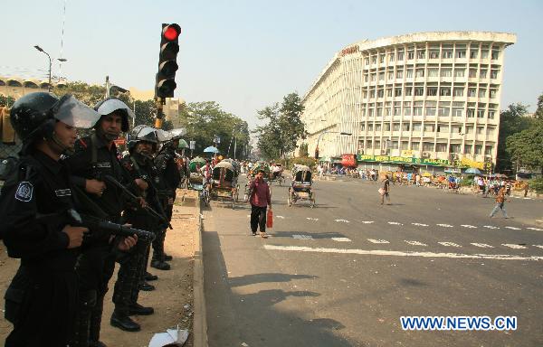 Bangladeshi police stand guard on the side of an almost empty road in Dhaka, capital of Bangladesh, Nov. 30, 2010. 