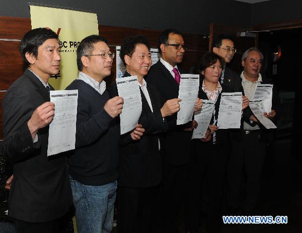 Representatives from various Chinese communities pose for photos during the launch of a petition for relaxing immigration regulations in the Chinatown, London, Britain, Nov. 30, 2010. 