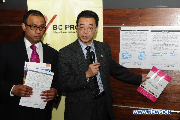 Former mayor of the London Borough of Redbridge Thomas Chan (R), the first Chinese mayor in Britain, together with Yawar Khan, president of the Federation of Bangladeshi Caterers UK, attend the launch of a petition for relaxing immigration regulations in the Chinatown, London, Britain, Nov. 30, 2010.